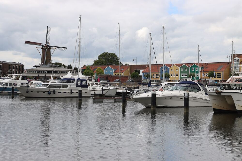 Jachthaven van Hellevoetsluis met boten, molen De Hoop en kleurige huizen aan de kade