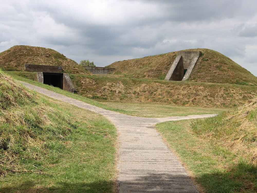 Houten pad tussen de grasbegroeide vestingwallen van Hellevoetsluis met een kazemat